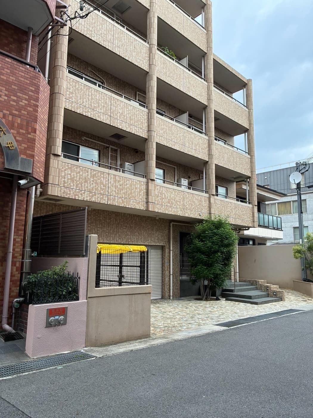 ベージュのタイル張りのマンション「六甲壱番館」の外観と入口