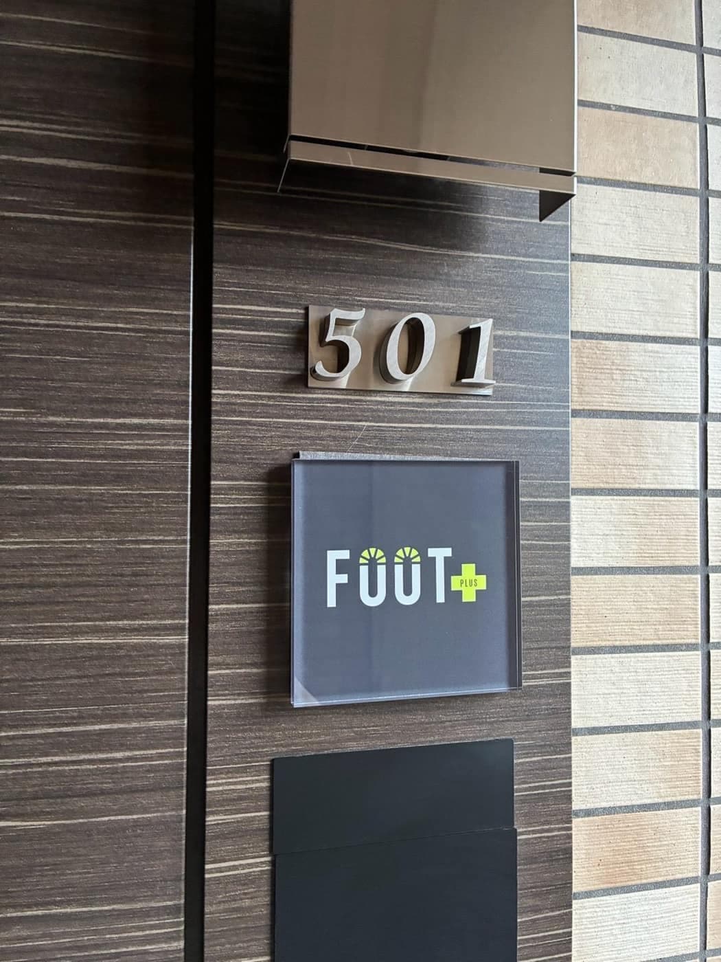 5階「501」の表示とFOOT+のロゴが掲げられた入口